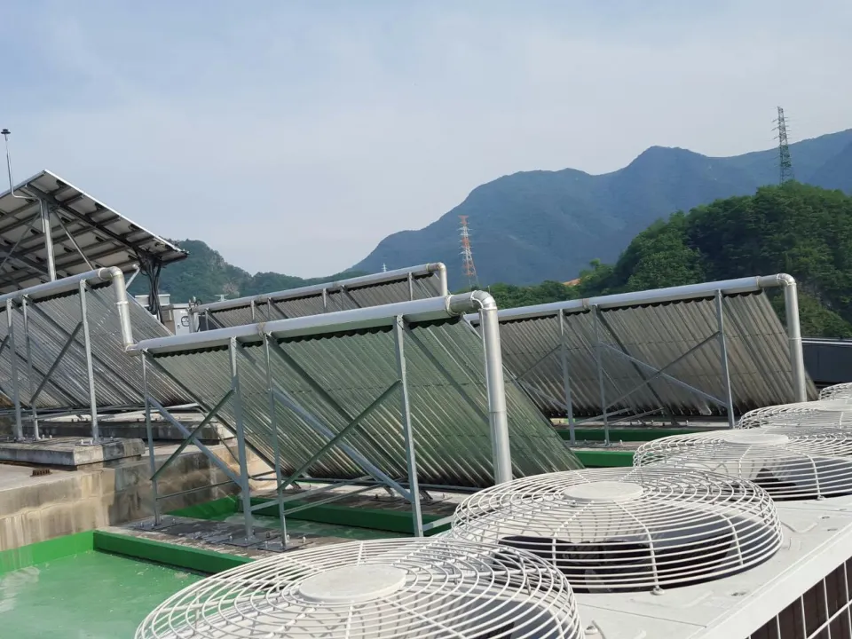 태양열난방 설치 — 옥상 집열기 열과 실외기, 산 배경